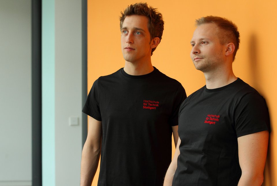 Zwei Studenten tragen T-Shirts mit HFT Logo