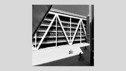 Schwarzwei? Architekturfotografie einer Stra?enszene mit Fahrradfahrern und Parkhaus im Hintergrund